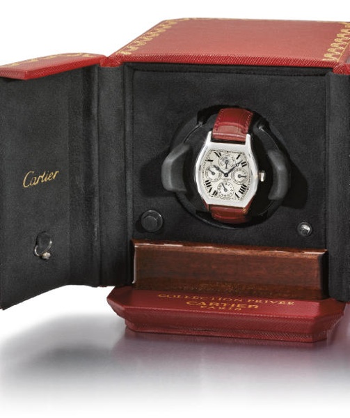 Cartier. A fine and large platinum tonneau-shaped self-winding two time zone perpetual calendar wristwatch