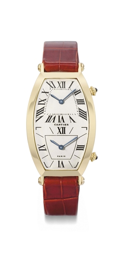 Cartier. AN 18K gold tonneau-shaped curved dual time wristwatch