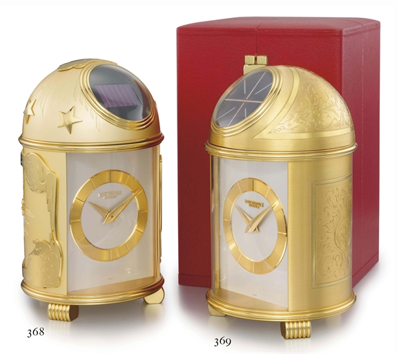 Patek Philippe. A fine and very rare gilt brass solar-powered table clock with original certificate, envelope and box