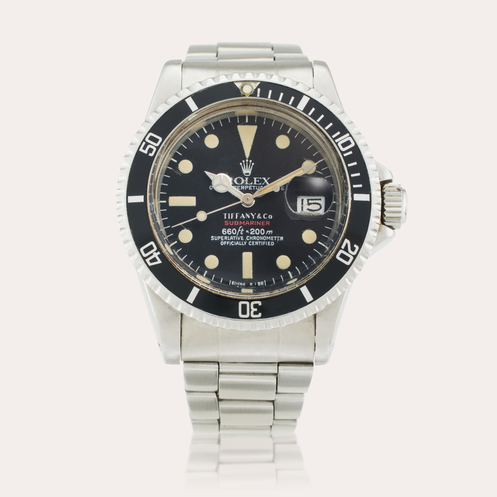 PROPERTY FROM THE FAMILY OF THE ORIGINAL OWNER Rolex Reference 1680 ‘Red’ Submariner | Retailed by Tiffany Co.: A stainless steel automatic wristwatch with date and bracelet, Circa 1974
