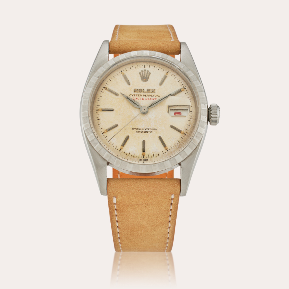 Rolex Reference 6305 2 Datejust | A stainless steel automatic wristwatch with date, engine turned bezel, and red date wheel, Circa 1952